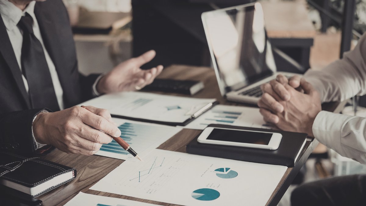 Business professionals reviewing charts and documents at a meeting table